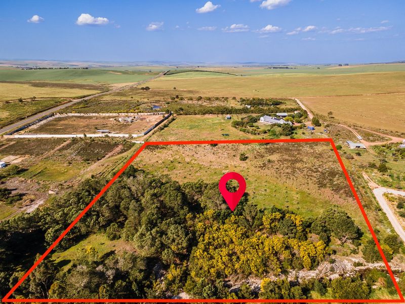 Aerial view of a large, undeveloped residential plot featuring native vegetation and clear boundary lines in a rural landscape setting.