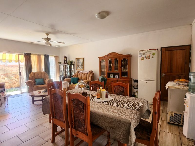 Spacious open-plan living and dining area featuring tiled flooring, a ceiling fan, and direct access to the outdoor patio through sliding glass doors.