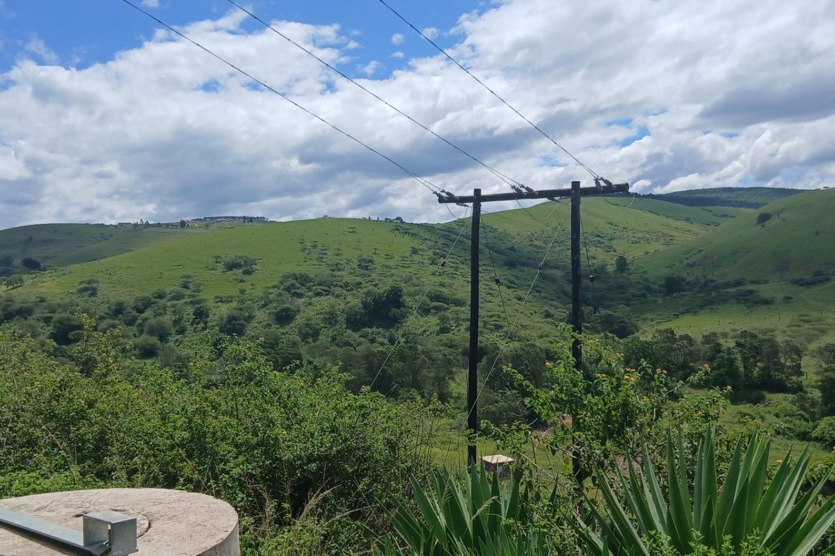A scenic view of the surrounding rolling green hills and landscape, featuring utility infrastructure in the foreground.