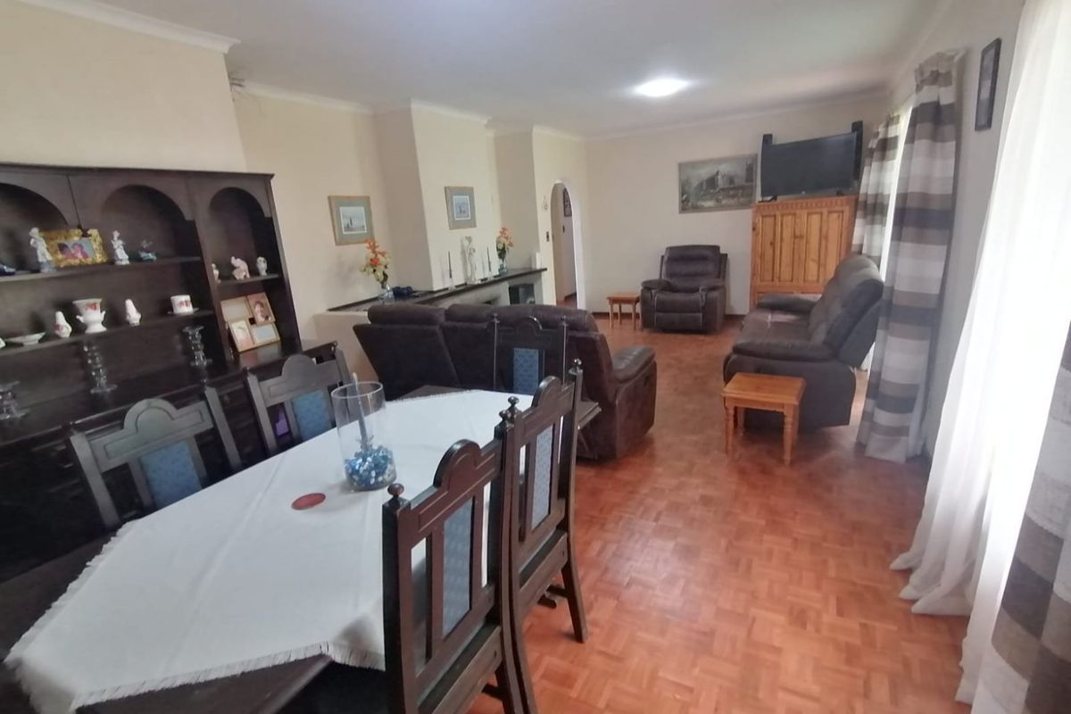Spacious open-plan living and dining area featuring classic parquet flooring and a traditional archway, offering a versatile layout for family living.