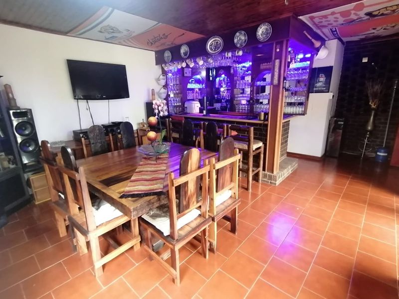 A dedicated entertainment area featuring a built-in bar with integrated shelving and tiled flooring, suitable for social gatherings and home hosting.