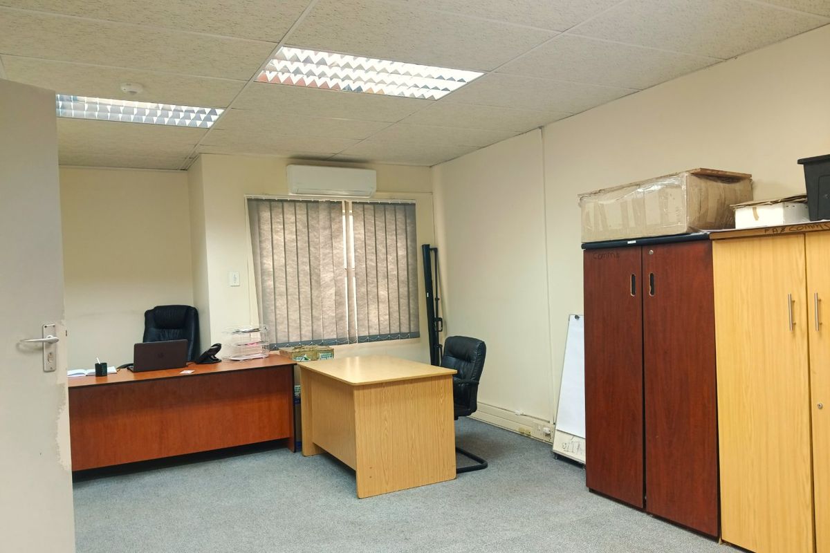 A functional commercial office space featuring a suspended ceiling, recessed lighting, split-system air conditioning, and carpeted flooring.