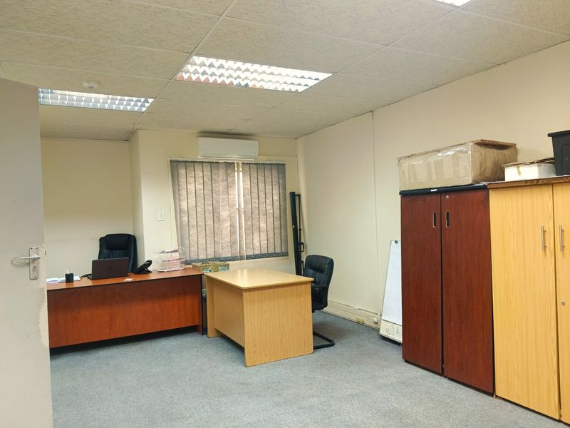A functional commercial office space featuring a suspended ceiling, recessed lighting, split-system air conditioning, and carpeted flooring.