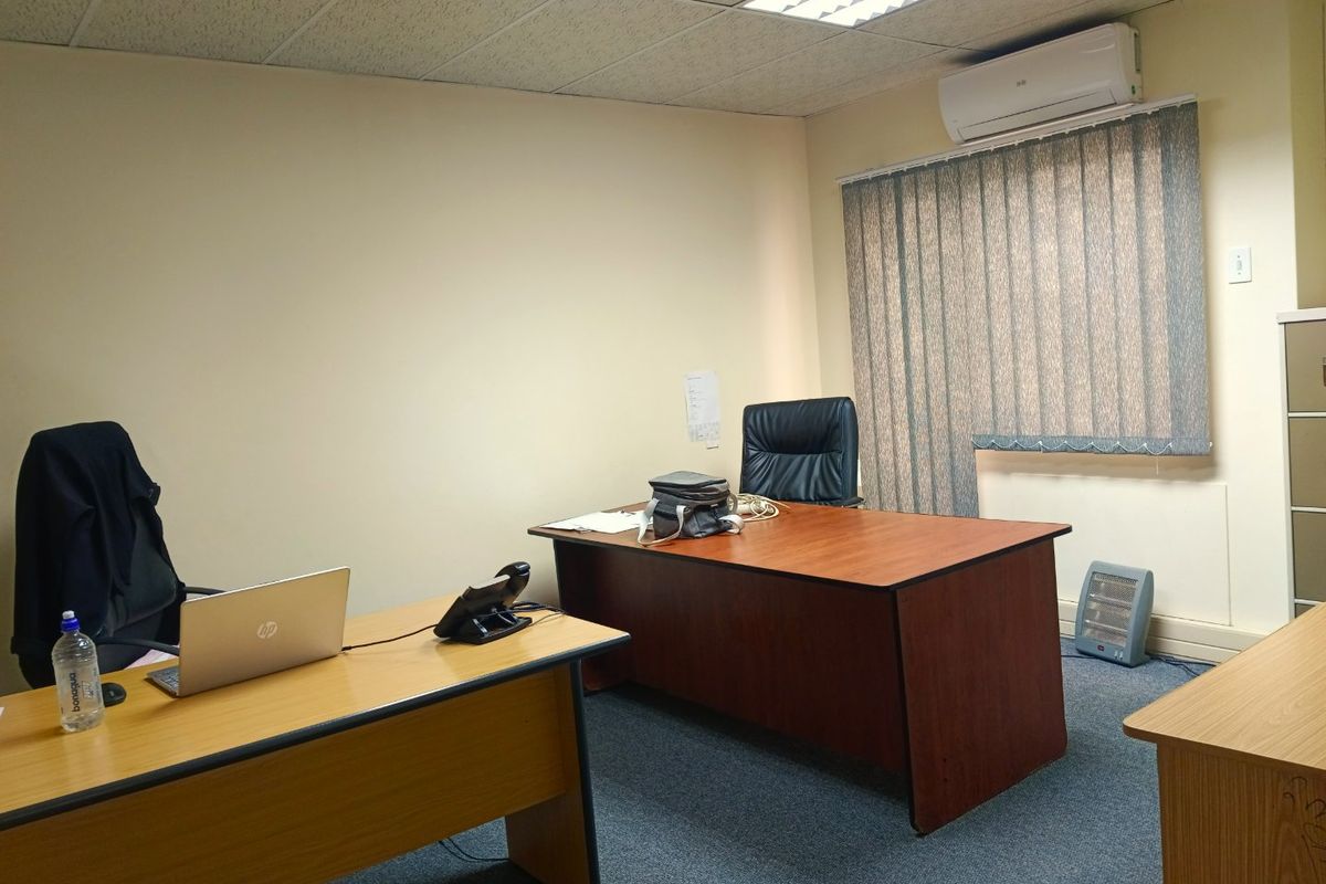 A functional commercial office space featuring a suspended ceiling, recessed lighting, split-system air conditioning, and carpeted flooring.