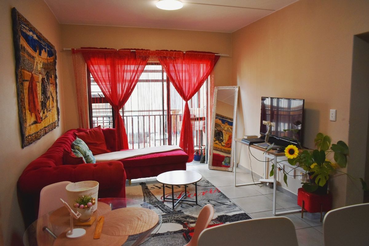 A living room featuring tiled flooring and a sliding glass door providing access to an outdoor balcony area.