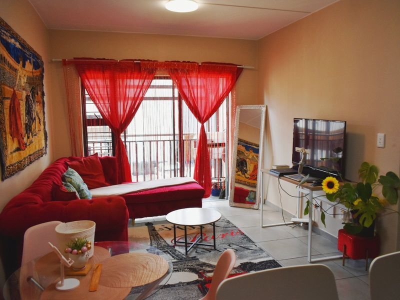 A living room featuring tiled flooring and a sliding glass door providing access to an outdoor balcony area.