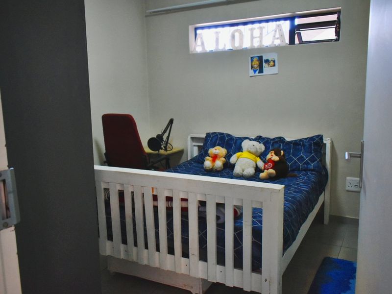 A compact bedroom featuring tiled flooring and a horizontal clerestory window, providing natural light to the space.