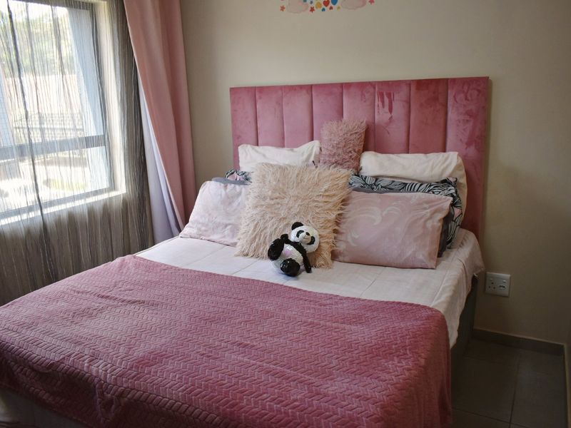 A bedroom featuring tiled flooring and a window with natural light, providing a functional space for rest.