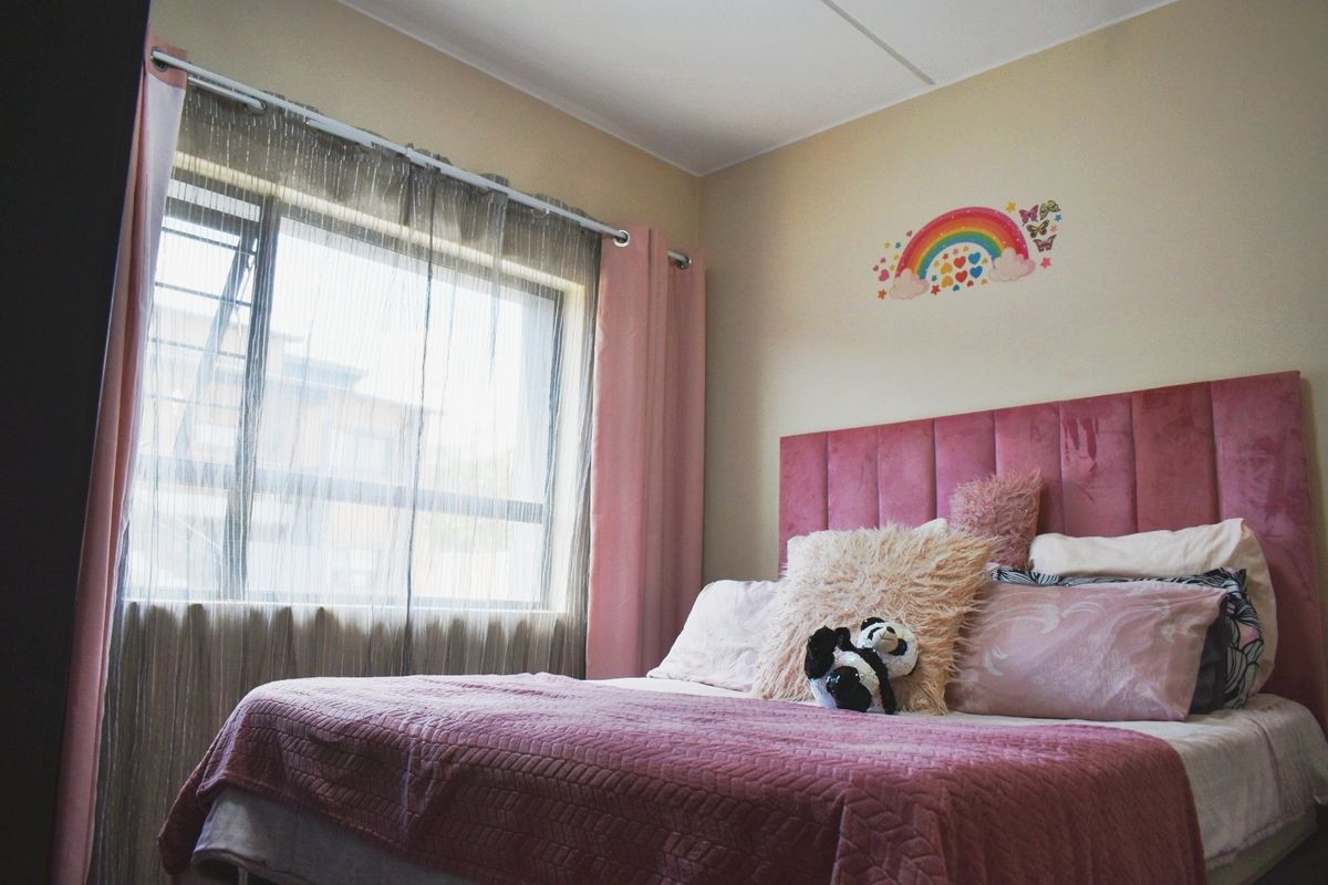 A bedroom featuring a large window with natural light and neutral wall finishes.