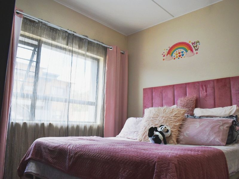 A bedroom featuring a large window with natural light and neutral wall finishes.