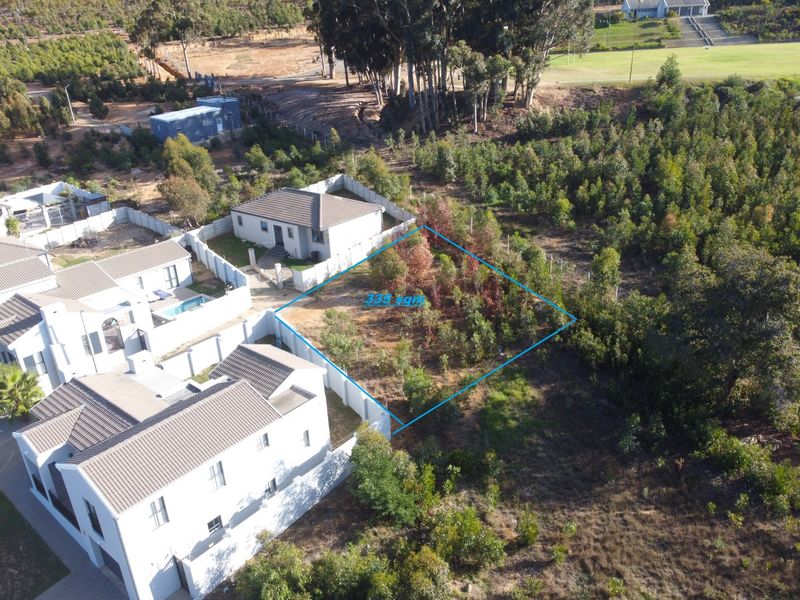 Aerial view of a vacant residential plot measuring 335 square meters, situated within a developed estate with established boundary fencing and surrounding vegetation.