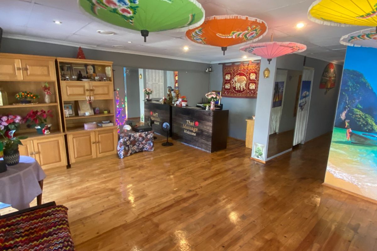 Commercial reception area featuring polished hardwood flooring, built-in reception desk, and integrated cabinetry, suitable for a professional service business.