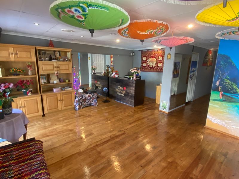 Commercial reception area featuring polished hardwood flooring, built-in reception desk, and integrated cabinetry, suitable for a professional service business.
