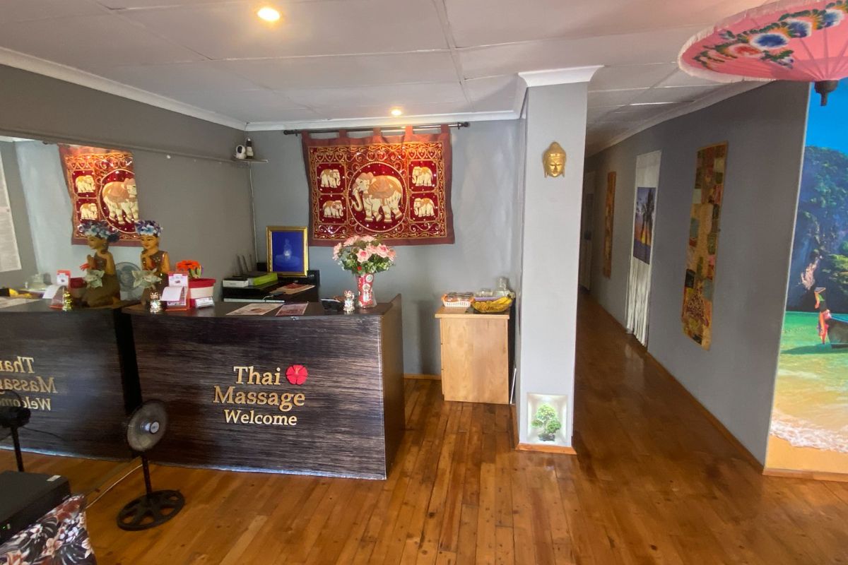 Commercial reception area featuring hardwood flooring, a built-in reception desk, and recessed ceiling lighting, providing a welcoming entrance for clients.