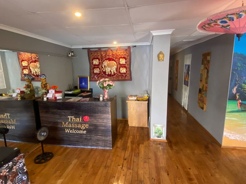 Commercial reception area featuring hardwood flooring, a built-in reception desk, and recessed ceiling lighting, providing a welcoming entrance for clients.