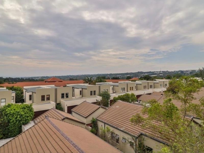 Elevated view overlooking the rooftops of a residential apartment complex under a cloudy sky.