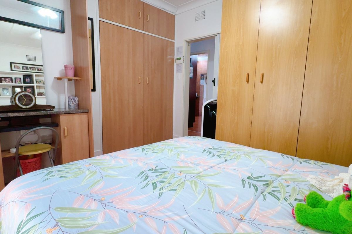 Bedroom featuring extensive built-in wooden cabinetry and integrated vanity unit, providing ample storage space.
