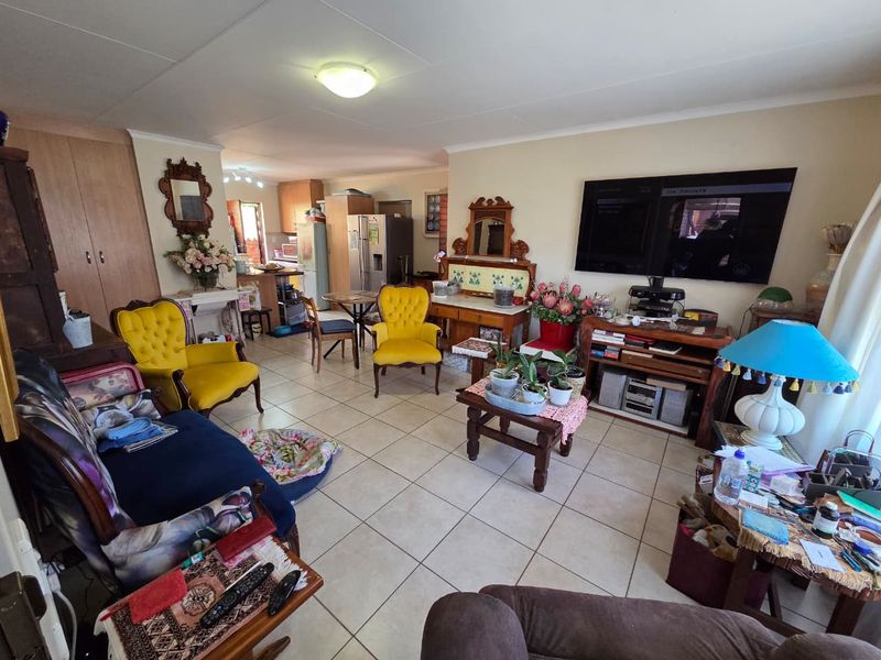 Open-plan living and kitchen area featuring tiled flooring and built-in cabinetry, offering a functional layout for daily living and entertaining.