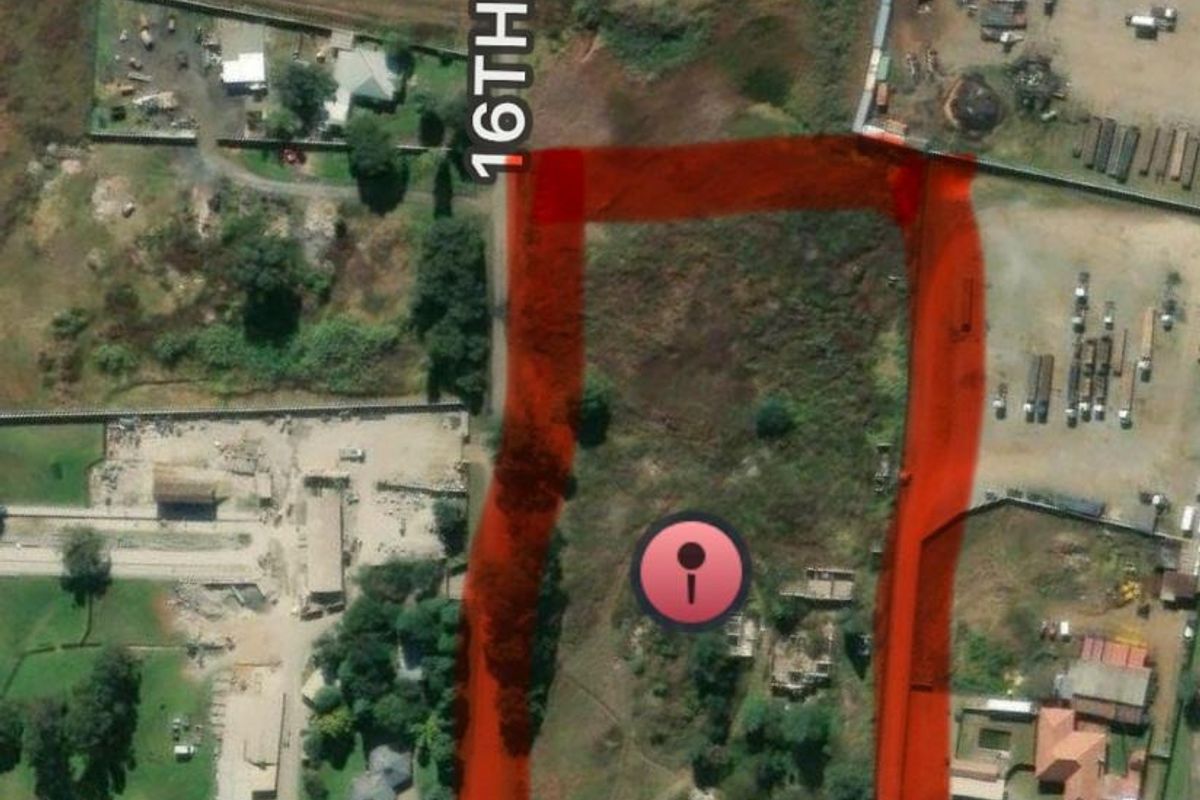 Aerial view of a vacant residential plot highlighted in red, situated with frontage along 16th Street.