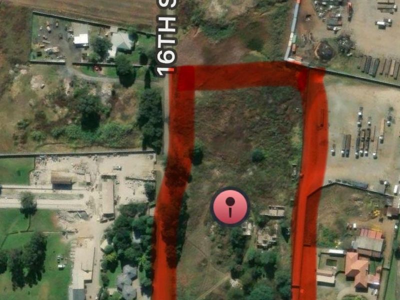 Aerial view of a vacant residential plot highlighted in red, situated with frontage along 16th Street.