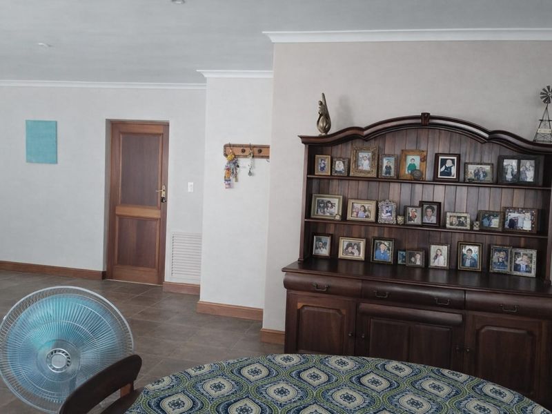 A living area featuring tiled flooring, coving, and a solid timber door, providing a neutral foundation for interior design updates.
