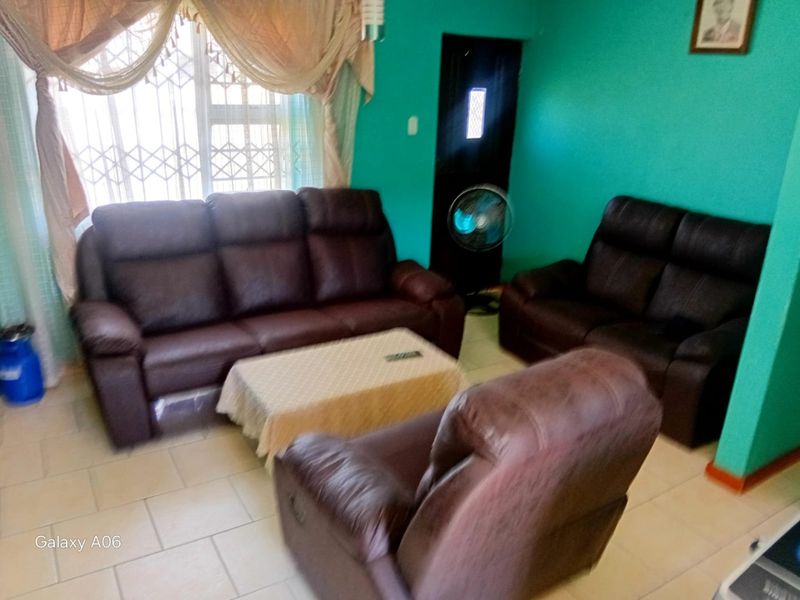 A living room featuring tiled flooring and a sliding door with an integrated security gate.