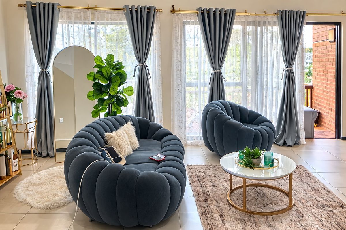 A bright and well-maintained living room featuring large glass sliding doors that provide ample natural light and access to an outdoor balcony area.