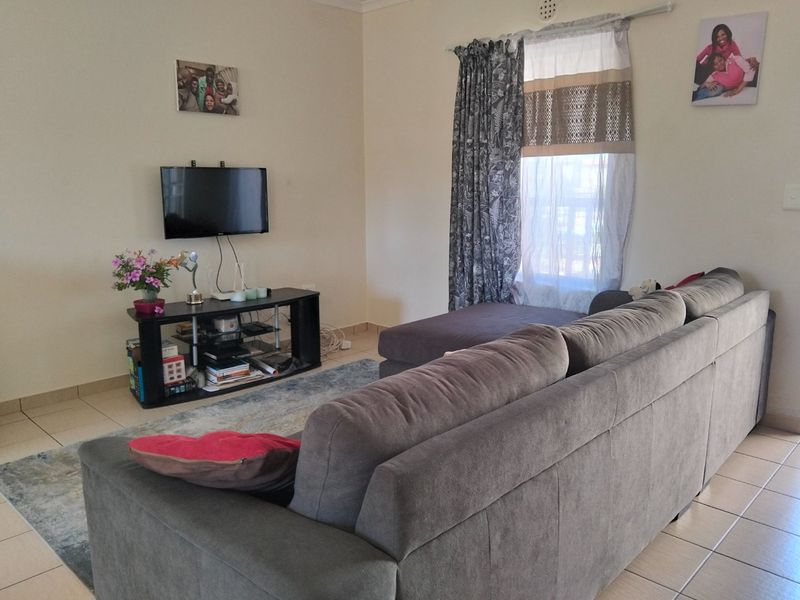 A functional living room featuring neutral walls and tiled flooring, providing a comfortable and versatile space for relaxation.