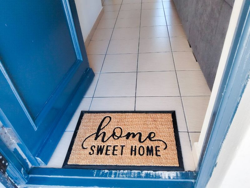 A view of the apartment entrance featuring tiled flooring and a painted door frame.