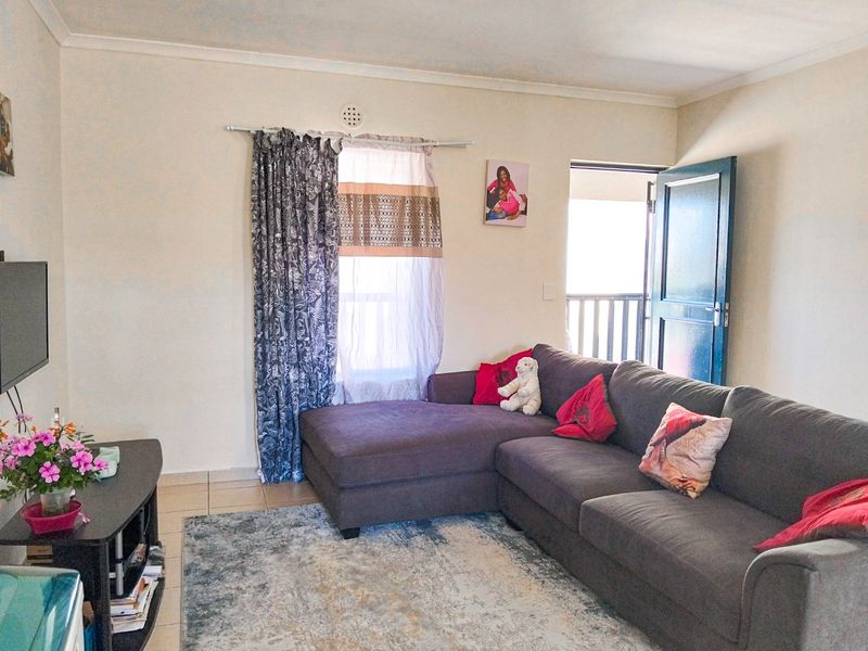 A comfortable living room featuring tiled flooring and direct access to an outdoor balcony area.