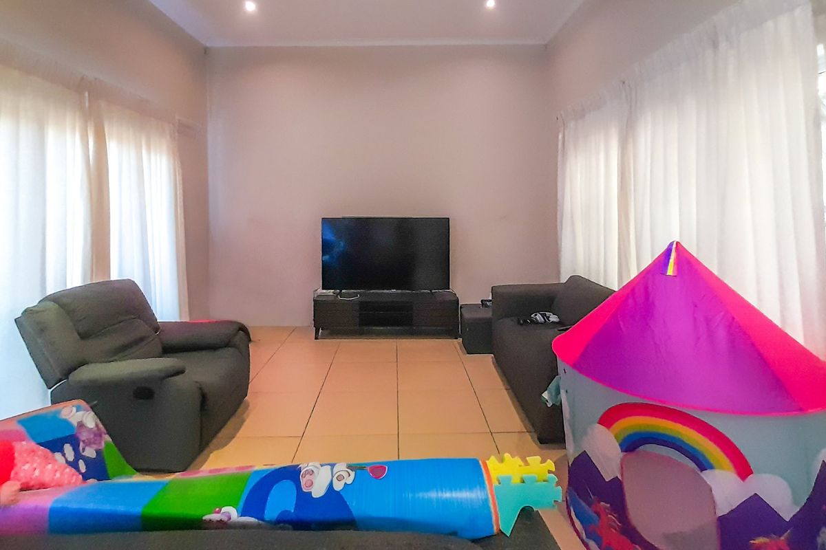 A living room featuring tiled flooring and recessed downlighting, offering a neutral base for interior design updates.