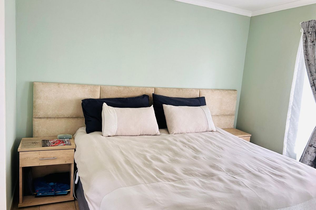 A bedroom featuring tiled flooring and a coved ceiling, providing a neutral base for personalization.