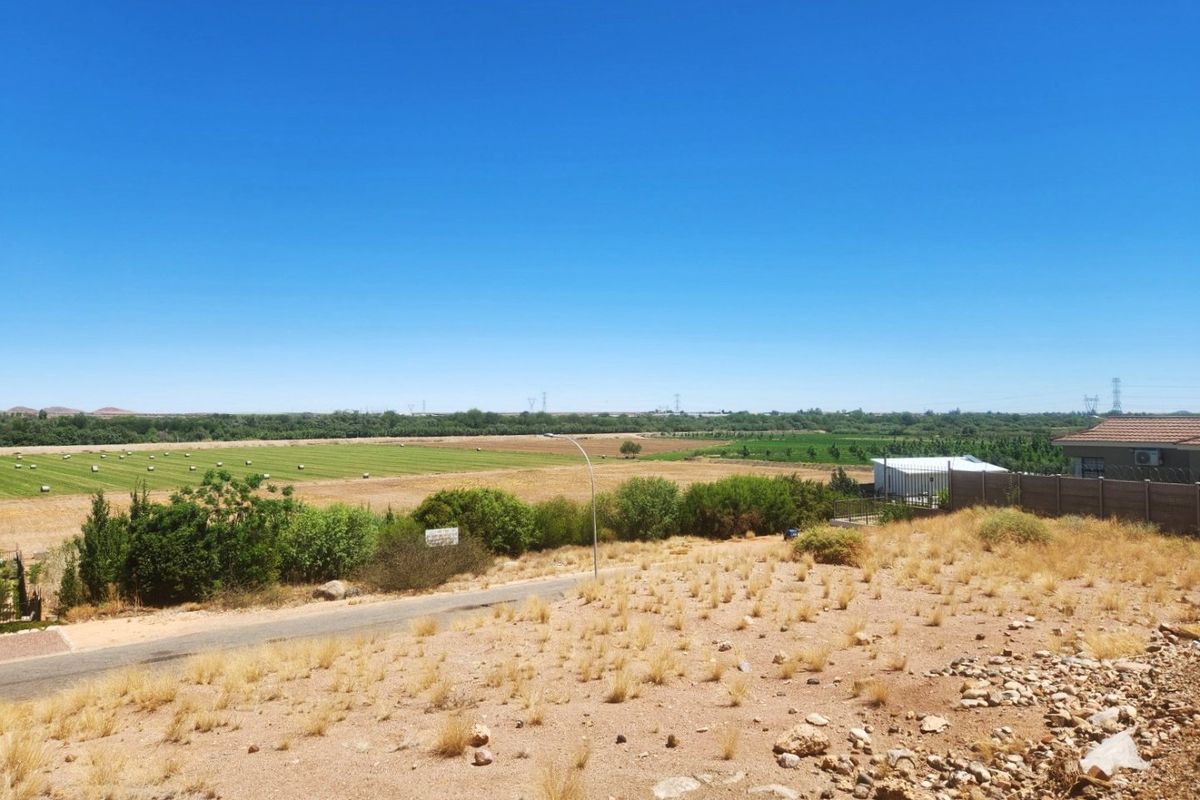 An elevated view overlooking a vacant residential plot with surrounding agricultural land and distant rural landscape.