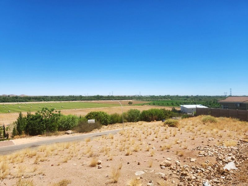 An elevated view overlooking a vacant residential plot with surrounding agricultural land and distant rural landscape.