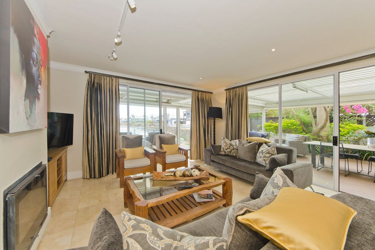 Spacious living room featuring stone tile flooring, a built-in fireplace, and large sliding glass doors that provide seamless access to the outdoor patio area.