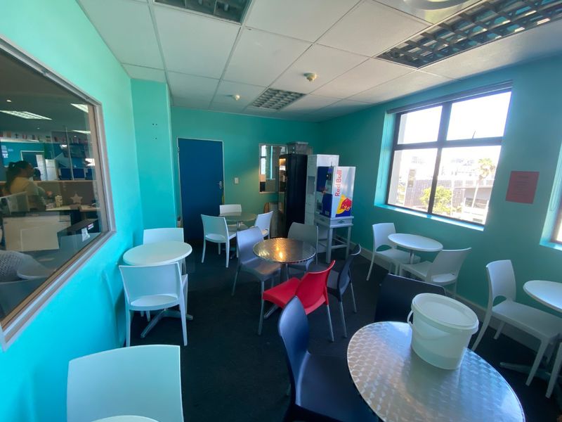 A commercial break-out or seating area featuring large windows, suspended ceilings, and bright wall finishes, suitable for office or communal use.