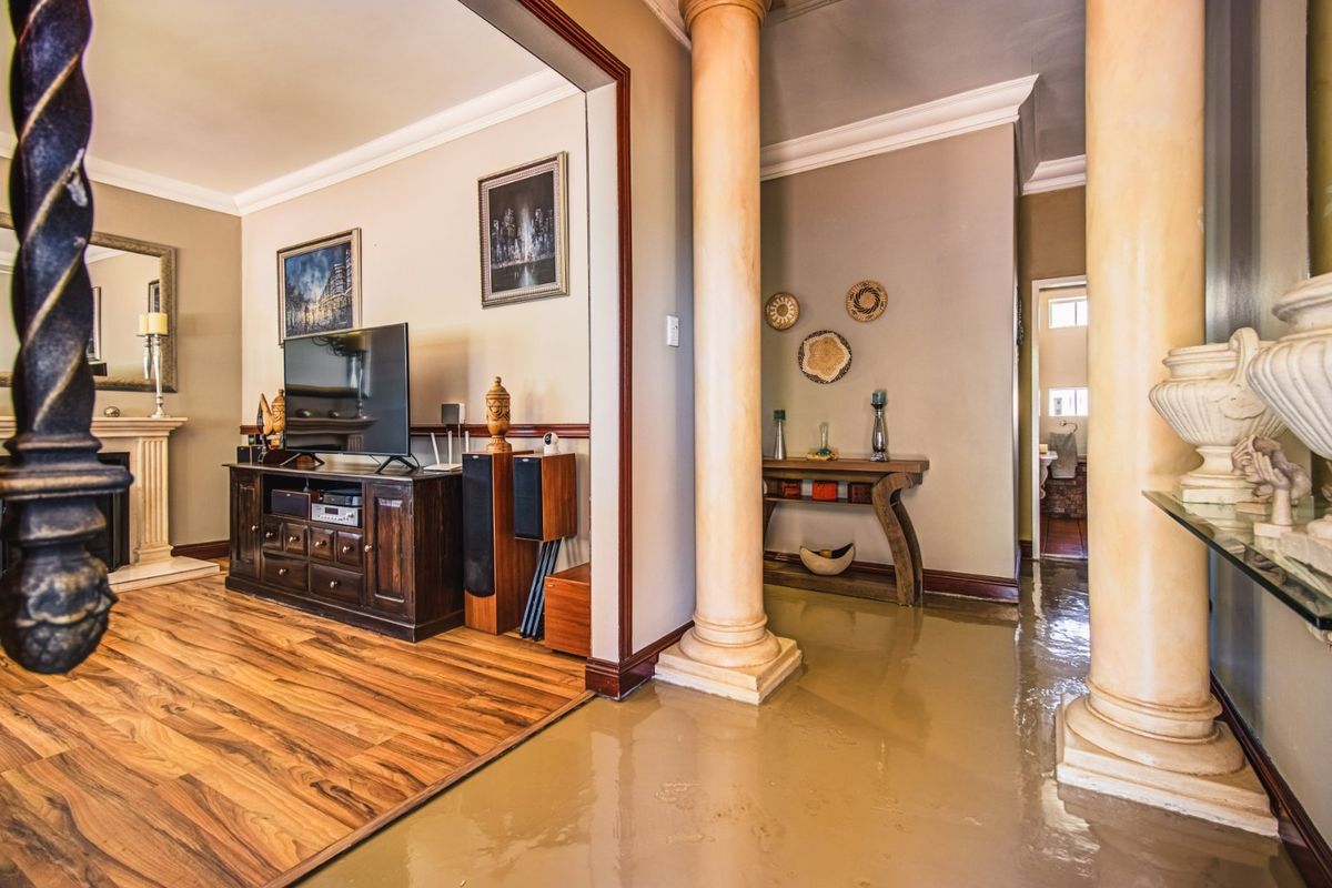 A well-maintained living area featuring decorative columns, a fireplace mantel, and laminate flooring, creating a warm and inviting atmosphere.