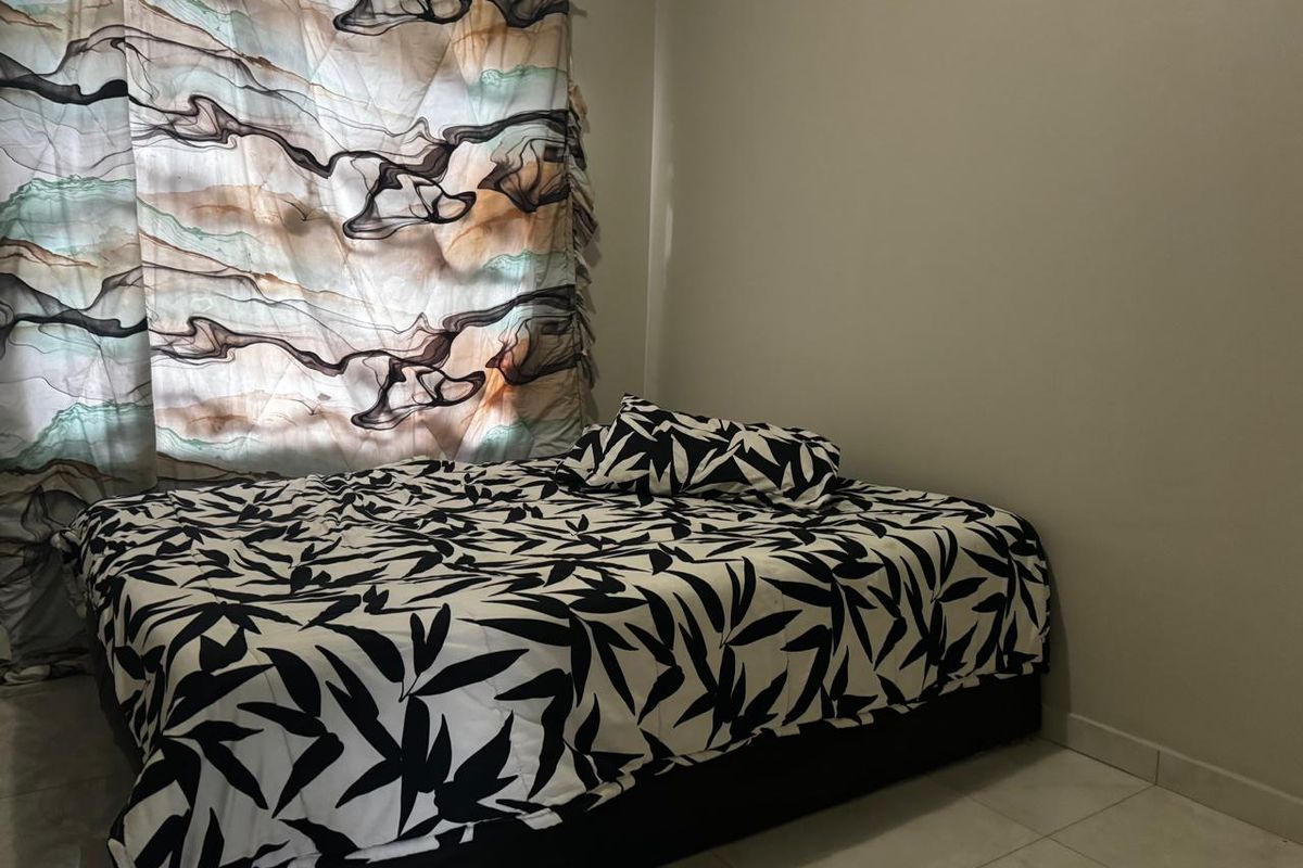 A simple bedroom featuring neutral wall finishes and tiled flooring, providing a functional space for rest.