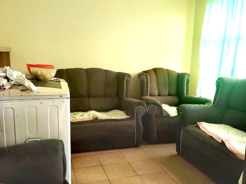 A living room area featuring tiled flooring and standard wall finishes, offering a functional space ready for modernization and aesthetic updates.