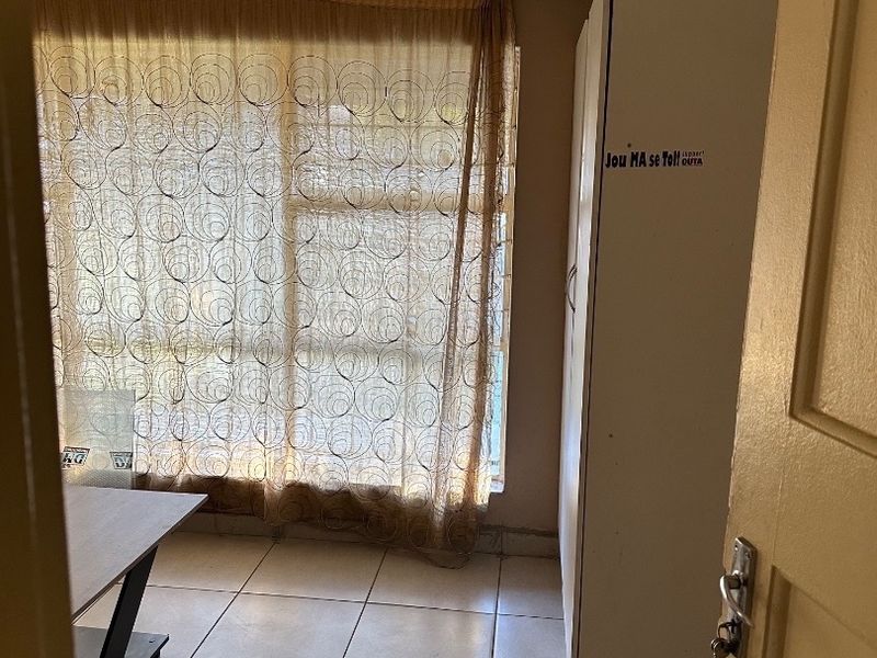 A bedroom featuring tiled flooring and a built-in cupboard, requiring minor cosmetic updates to improve the overall aesthetic and condition of the space.