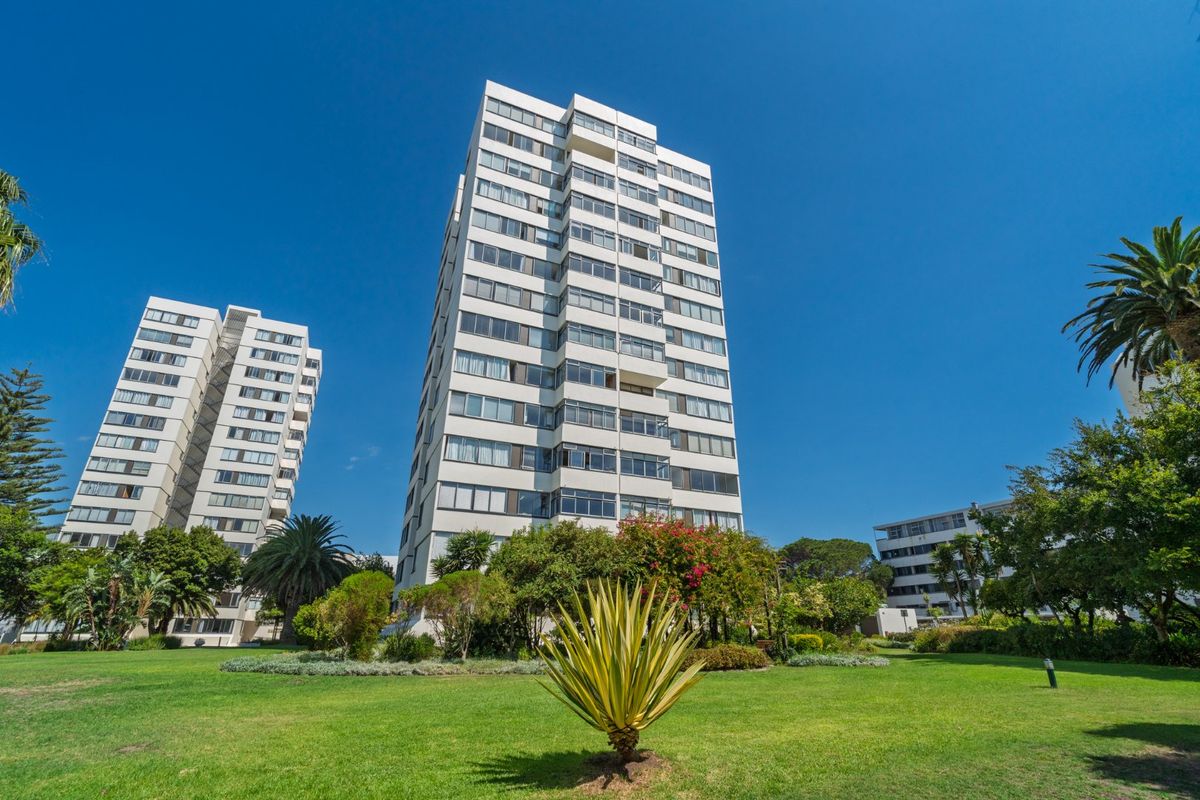 Exterior view of a multi-story apartment building set within a well-maintained landscaped garden area.