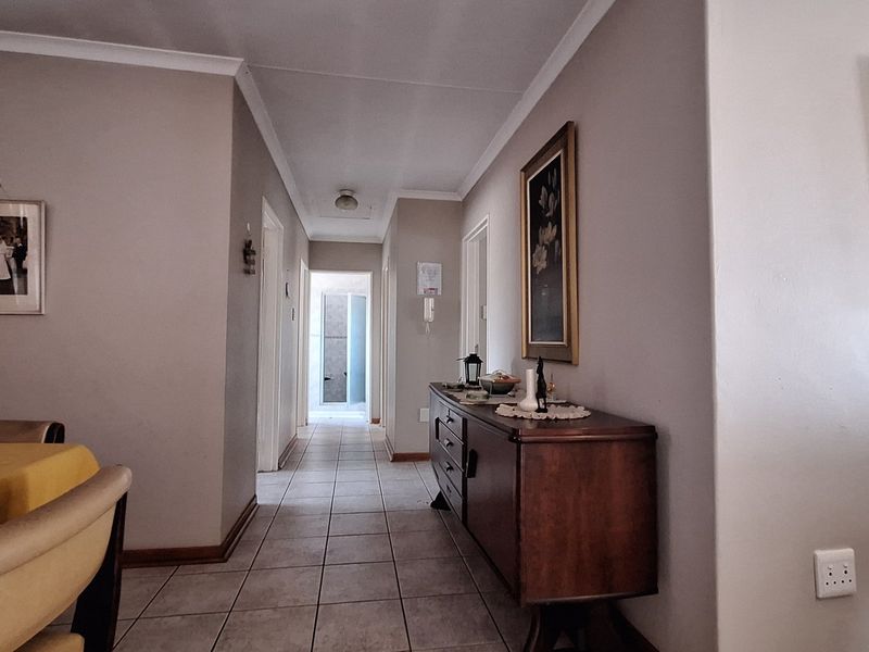 A functional hallway featuring neutral wall tones and tiled flooring, providing access to various rooms within the townhouse.