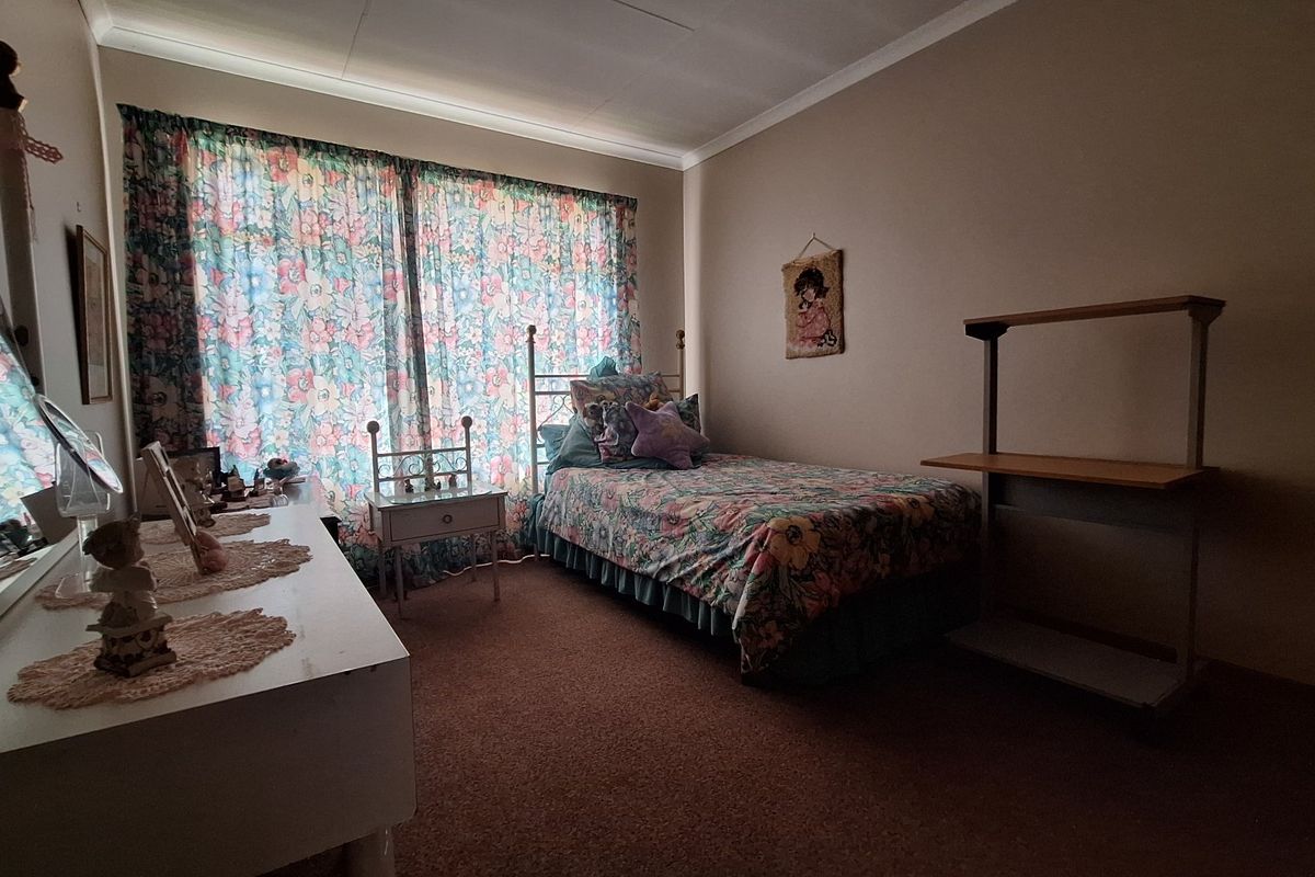 A bedroom featuring carpeted flooring and coved ceiling details, offering a functional space ready for modernization.