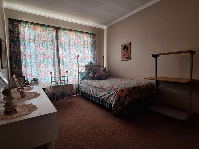 A bedroom featuring carpeted flooring and coved ceiling details, offering a functional space ready for modernization.