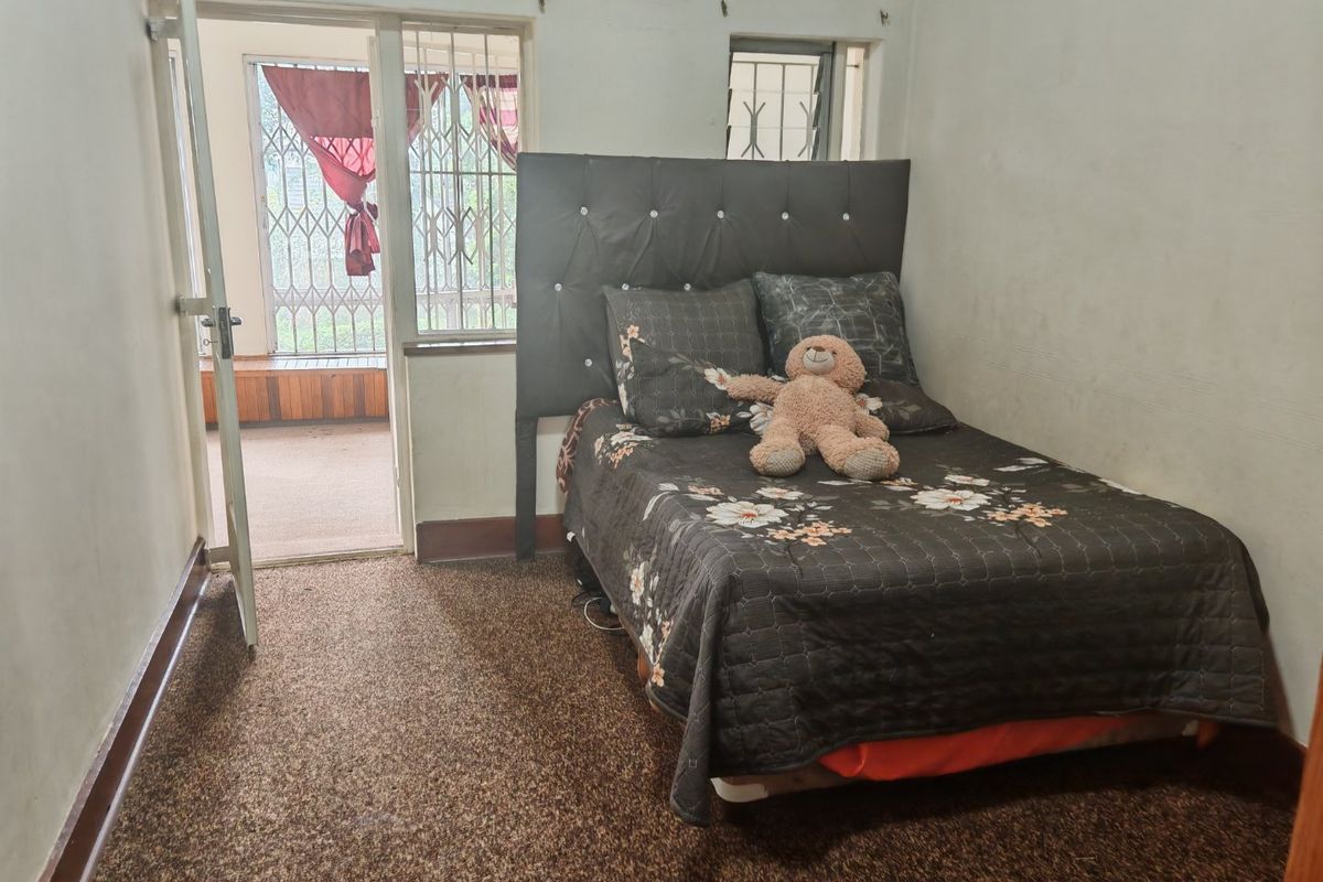 A bedroom featuring carpet flooring and direct access to an outdoor area through a security gate.