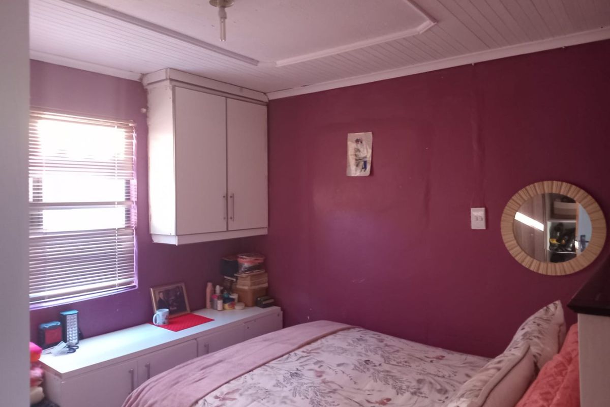 A bedroom featuring built-in cabinetry, tongue and groove ceiling panels, and venetian blinds. The room requires cosmetic updates to improve its overall aesthetic appeal.