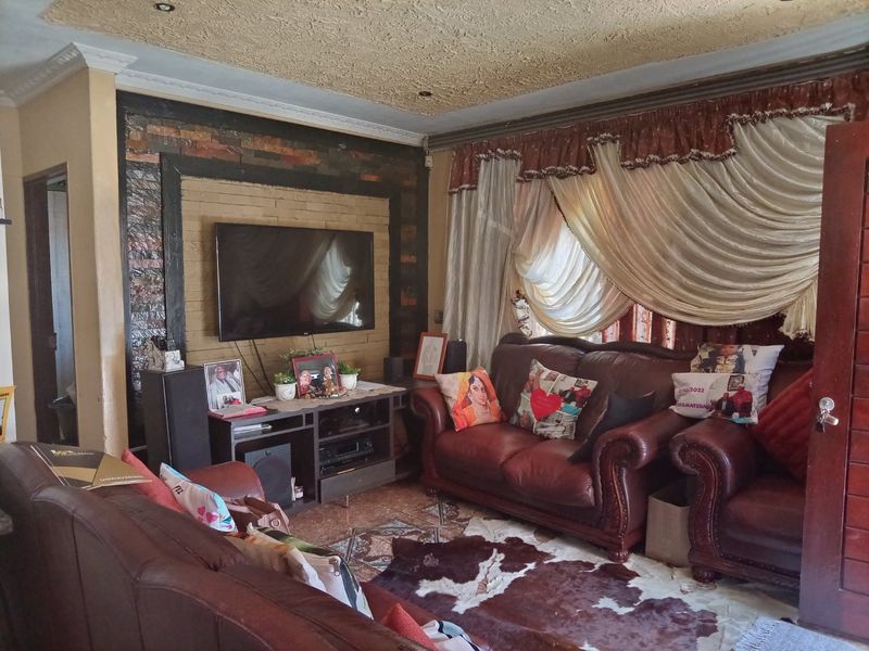 A living room featuring a textured ceiling, stone accent wall, and tiled flooring, providing a functional space for relaxation.