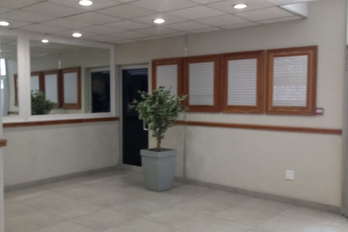 A spacious entrance area featuring tiled flooring, a drop ceiling with recessed lighting, and decorative wall mirrors.