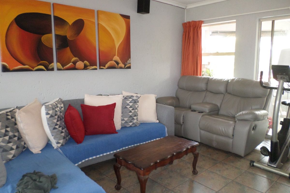 A living room area featuring tiled flooring and a sliding door providing access to the exterior.