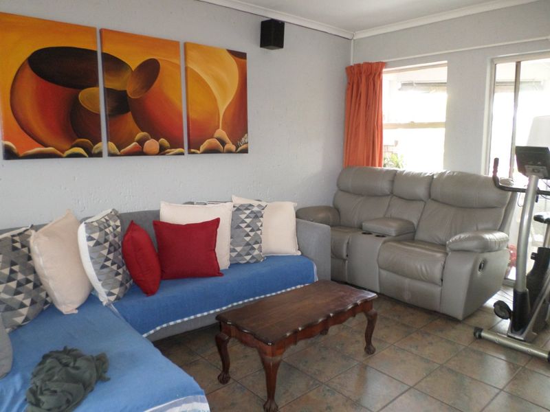A living room area featuring tiled flooring and a sliding door providing access to the exterior.